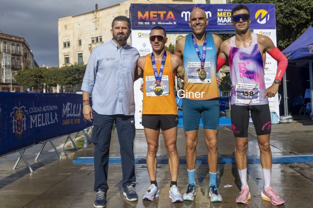 Reyes Estévez y otros corredores en la meta de la Media Maratón de Melilla