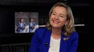 Nadia Calviño sonriente junto a su libro sobre su experiencia en el Gobierno.