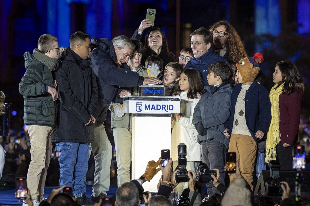 Carlos Sainz y niños presionando el botón de encendido navideño en Madrid