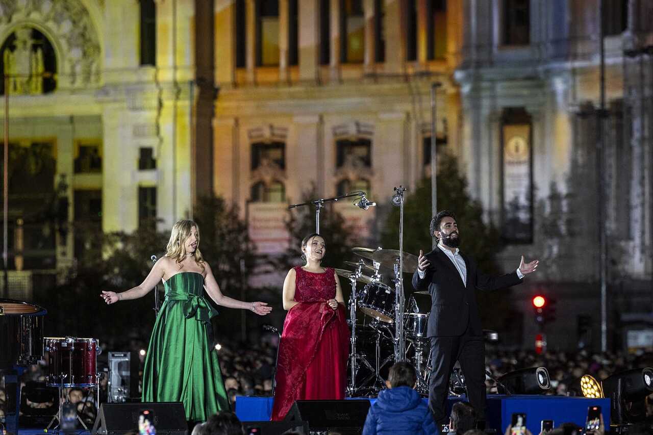 Tres cantantes en un escenario durante el encendido navideño en Madrid