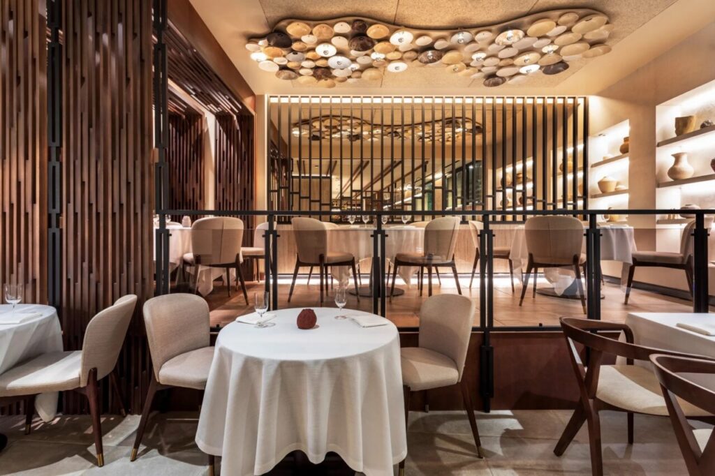 Interior del restaurante Per Se Bistró con mesas y decoración moderna.