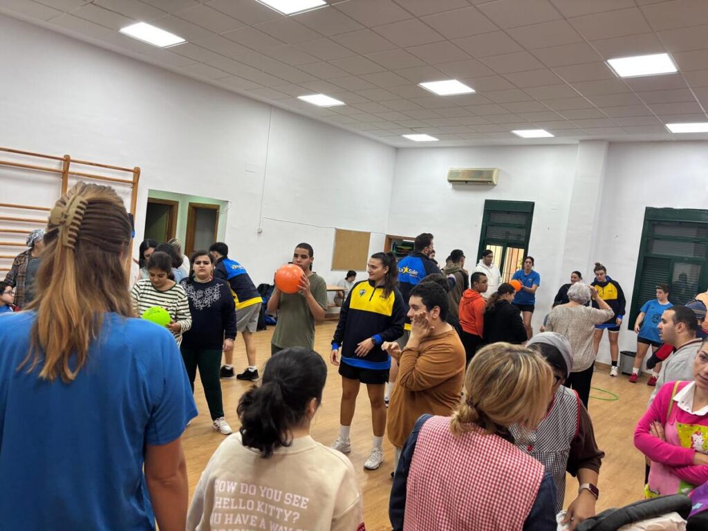 Jugadores y alumnos interactuando en el gimnasio del CEE Reina Sofía.