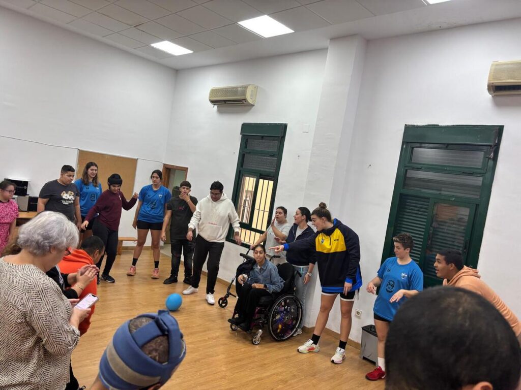 Jugadores del MCD La Salle interactuando con alumnos en un gimnasio