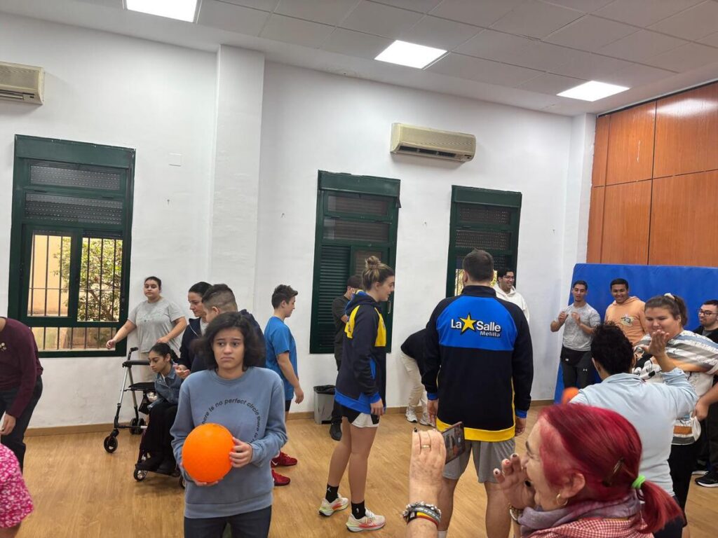 Jugadores y alumnos interactuando en el gimnasio del CEE Reina Sofía.