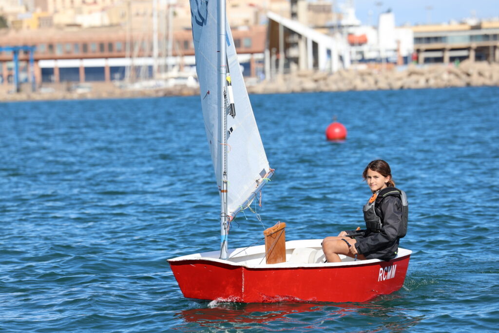 Joven navegante en una embarcación de vela ligera durante la regata.