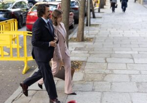Alberto González Amador y una mujer caminando por la calle durante un evento judicial.