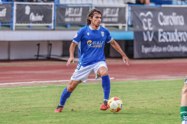 Álex Claverías jugando al fútbol con la U.D. Melilla en el campo.