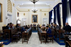 Reunión de la Asamblea con miembros sentados en mesas de trabajo