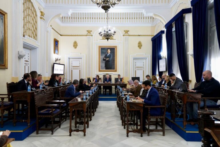 Reunión de la Asamblea con miembros sentados en mesas de trabajo
