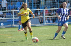 Jugadora del ATM Melilla corriendo con el balón en un partido de fútbol