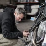 Hombre trabajando en la reparación de una motocicleta en un taller
