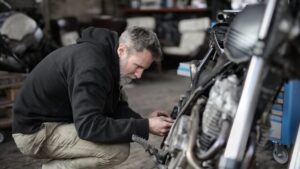 Hombre trabajando en la reparación de una motocicleta en un taller