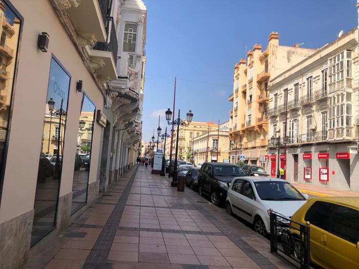Avenida en Melilla con edificios y coches estacionados