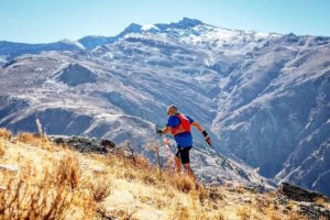 Corredor en una carrera de montaña en Melilla con paisajes montañosos al fondo.