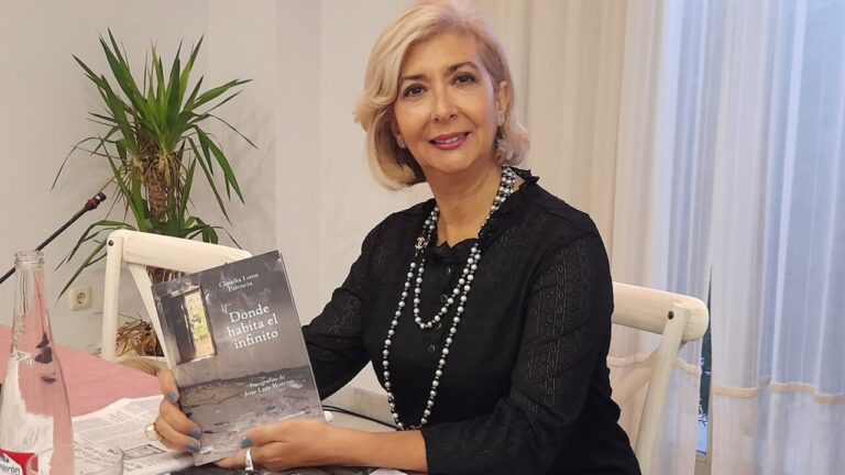 Claudia Luna sosteniendo su libro de poemas en un evento