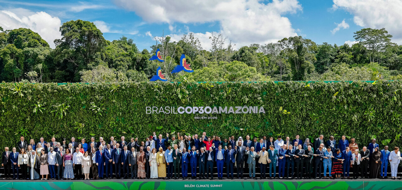 Representantes de países en la cumbre COP30 en Brasil con vegetación de fondo.