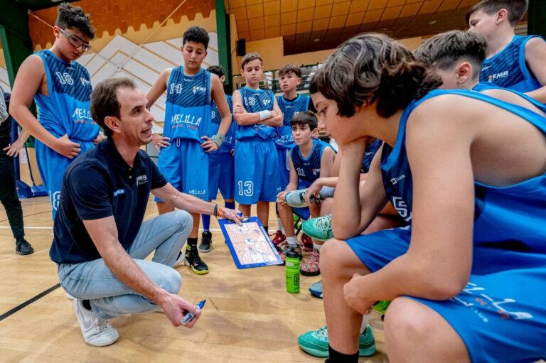 Entrenador explicando tácticas a jóvenes jugadores de baloncesto