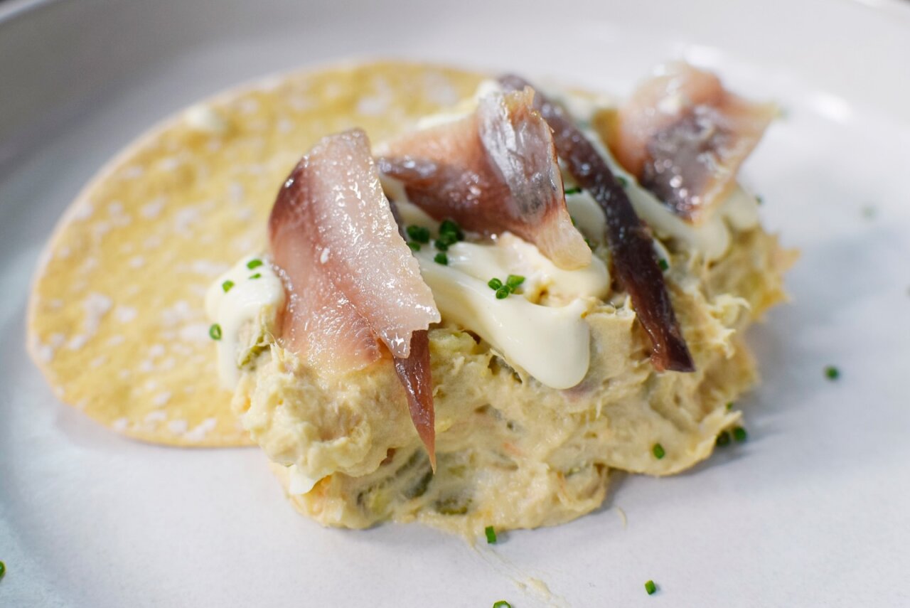 Plato de ensaladilla rusa con anchoas y mayonesa