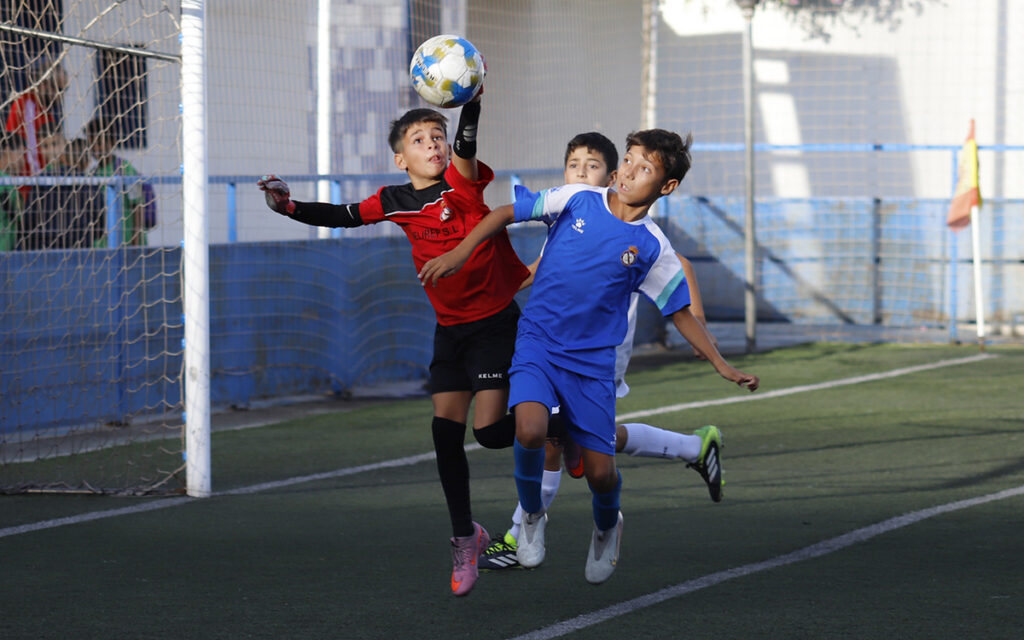 Niños jugando al fútbol en un partido de la Copa Federación Alevín.
