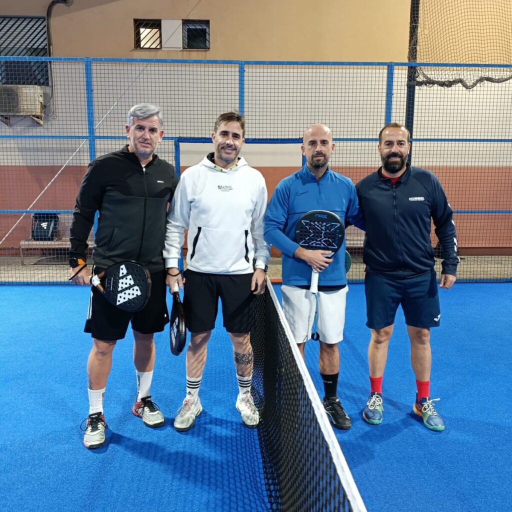 Cuatro jugadores de pádel posando en la cancha