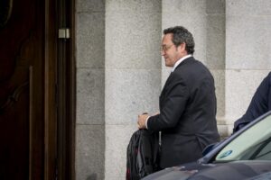 Fiscal García Ortiz saliendo de un edificio con una mochila.