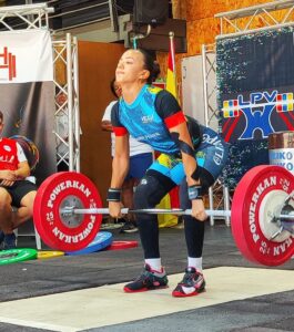 Atleta levantando pesas en un campeonato de halterofilia.