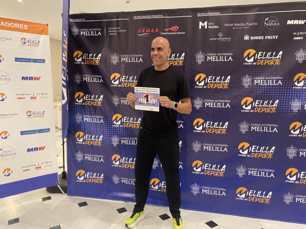 Reyes Estévez sosteniendo su dorsal en la Media Maratón de Melilla