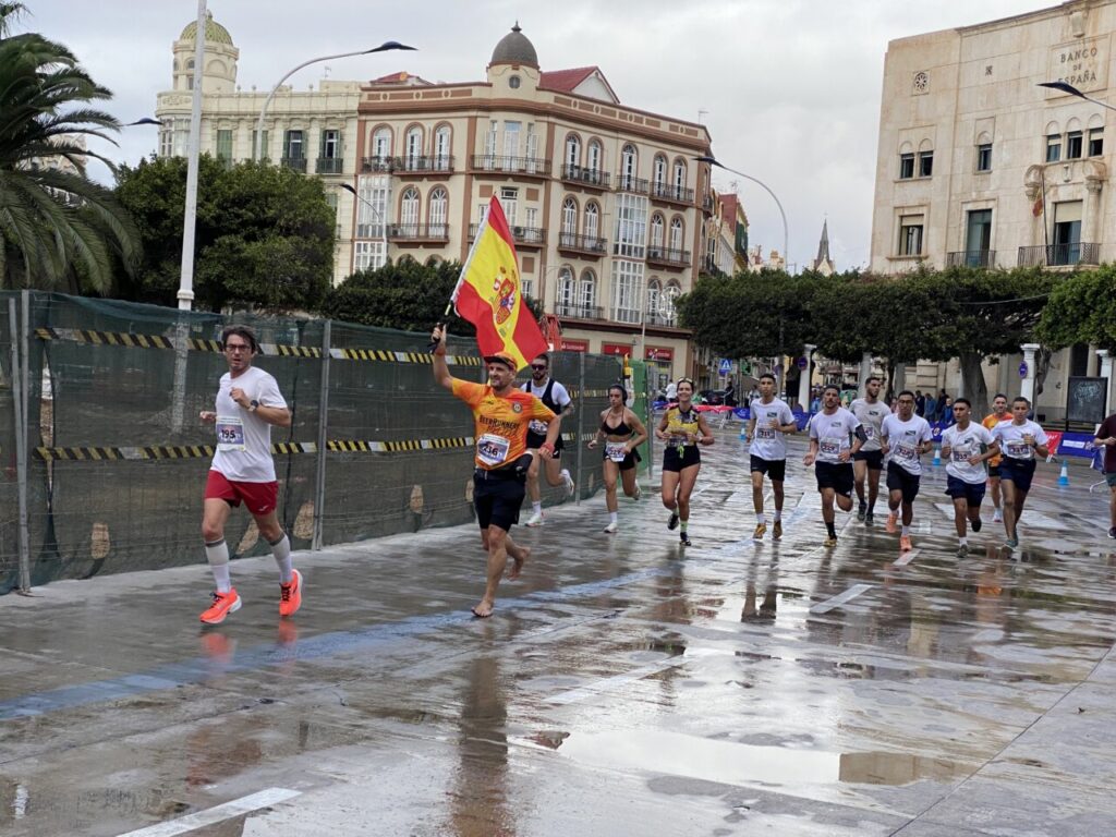 Corredores en la Media Maratón de Melilla con bandera española