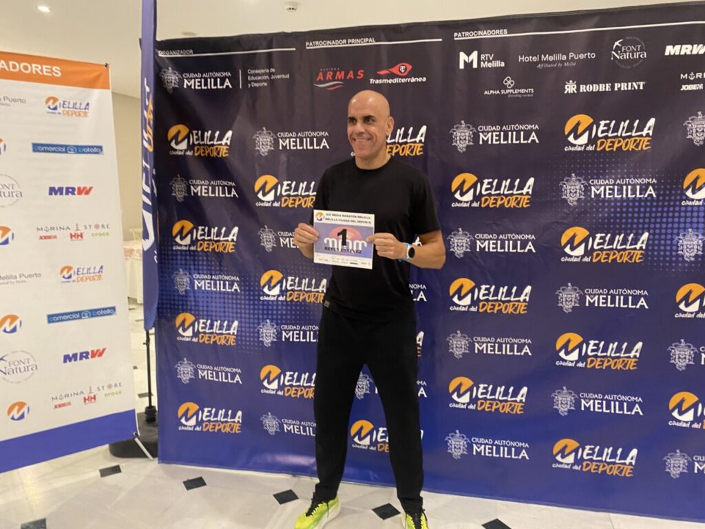 Reyes Estévez sosteniendo su dorsal en la Media Maratón de Melilla
