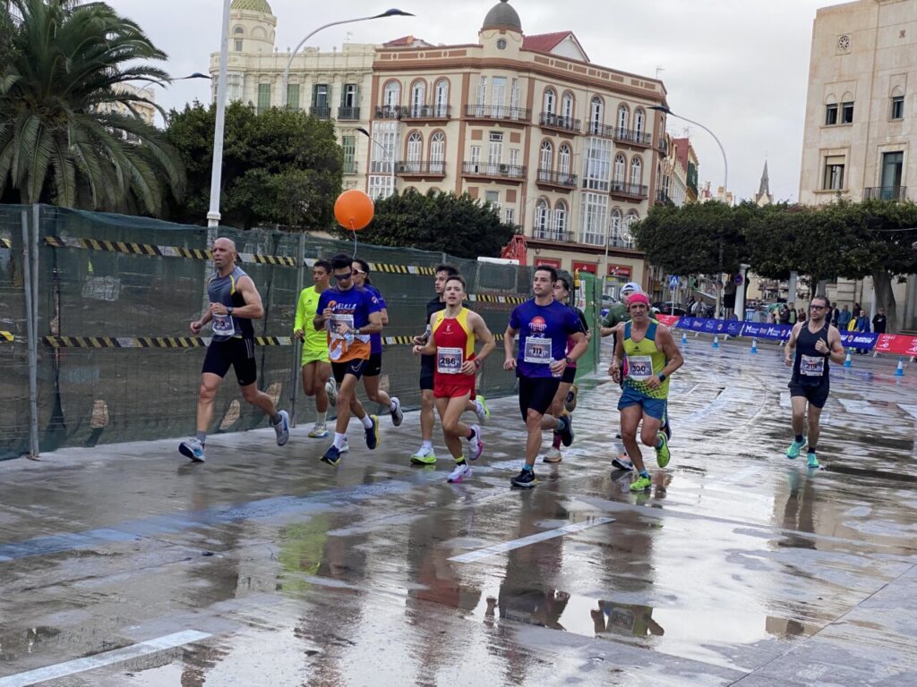 Corredores participando en la Media Maratón de Melilla bajo la lluvia.