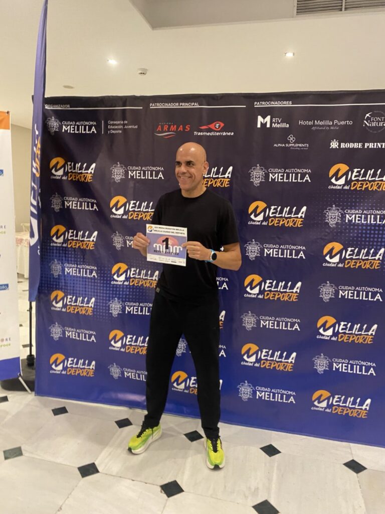 Reyes Estévez sosteniendo su dorsal en la Media Maratón de Melilla