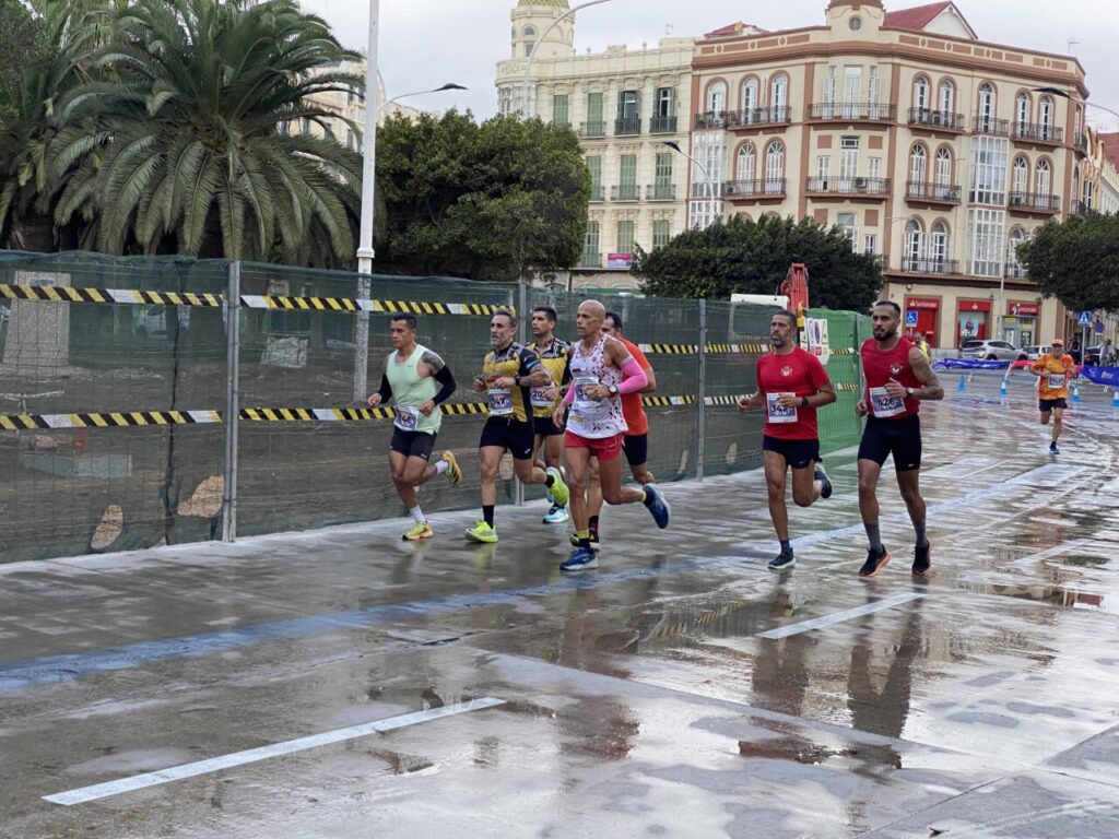 Corredores participando en la Media Maratón de Melilla bajo la lluvia.