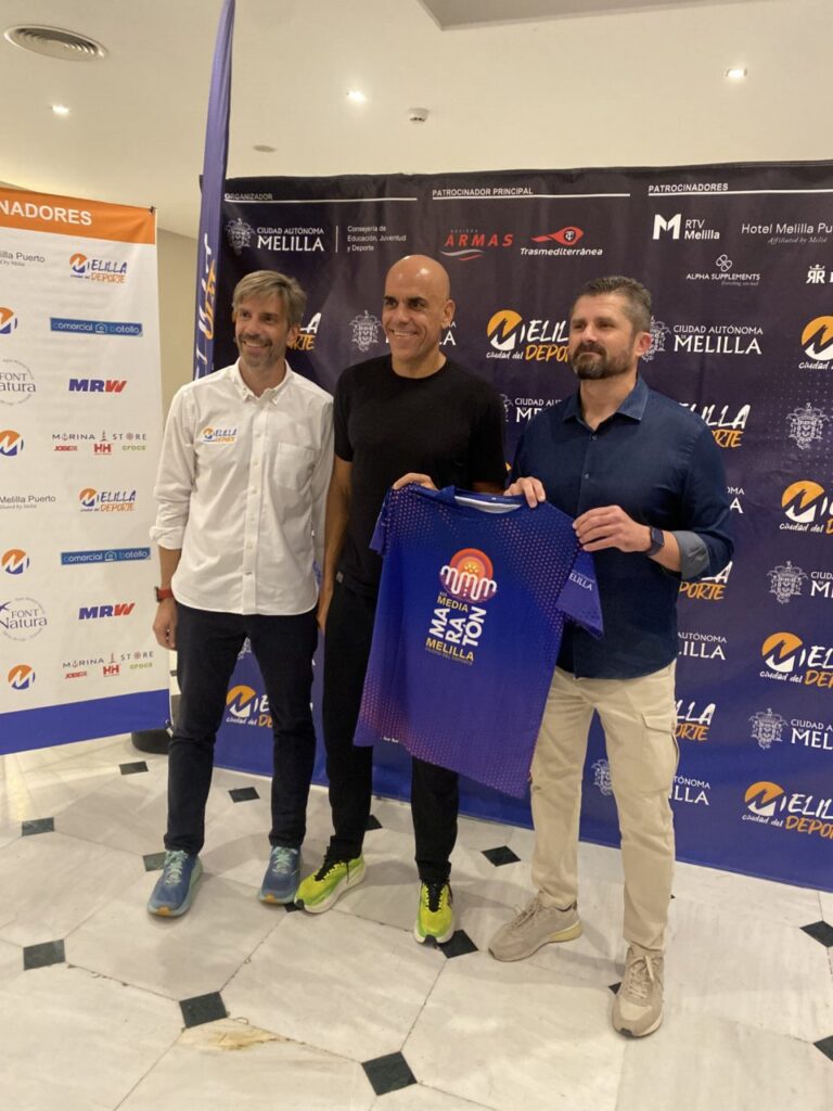 Reyes Estévez sosteniendo camiseta en evento de media maratón en Melilla