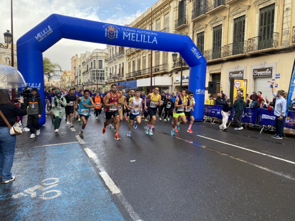 Corredores iniciando la Media Maratón de Melilla bajo la lluvia.