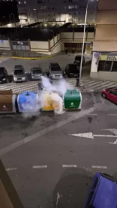 Contenedores de reciclaje ardiendo en una calle de la ciudad