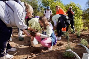 Grupo de personas plantando en el Jardín de los Valores en Melilla.