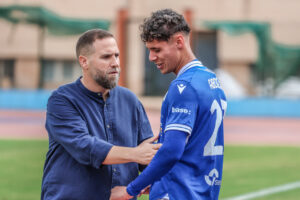 Javi Motos hablando con un jugador del Xerez Deportivo FC en el campo