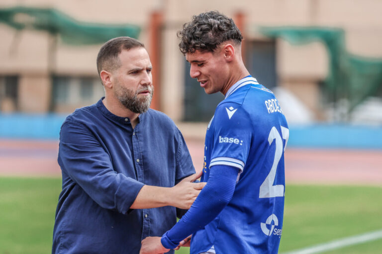 Javi Motos hablando con un jugador del Xerez Deportivo FC en el campo