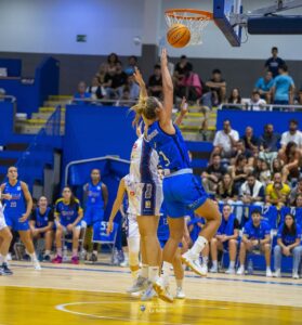 Jugadora de baloncesto saltando para encestar en un partido