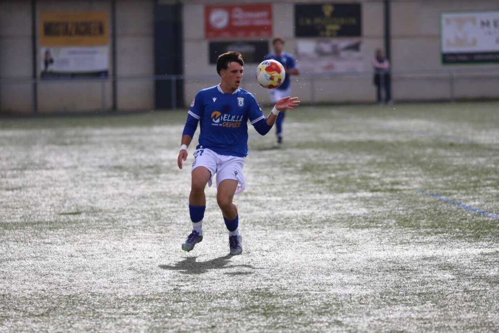 Jugador de la U.D. Melilla con balón en el campo durante un partido