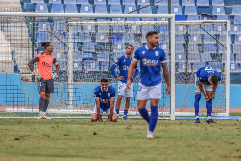Jugadores de la U.D. Melilla mostrando frustración tras un empate contra el Xerez DFC.