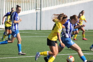 Jugadoras de fútbol femenino compiten en un partido en campo de césped
