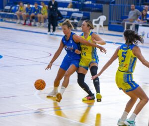 Jugadoras de baloncesto compitiendo en un partido en la cancha.