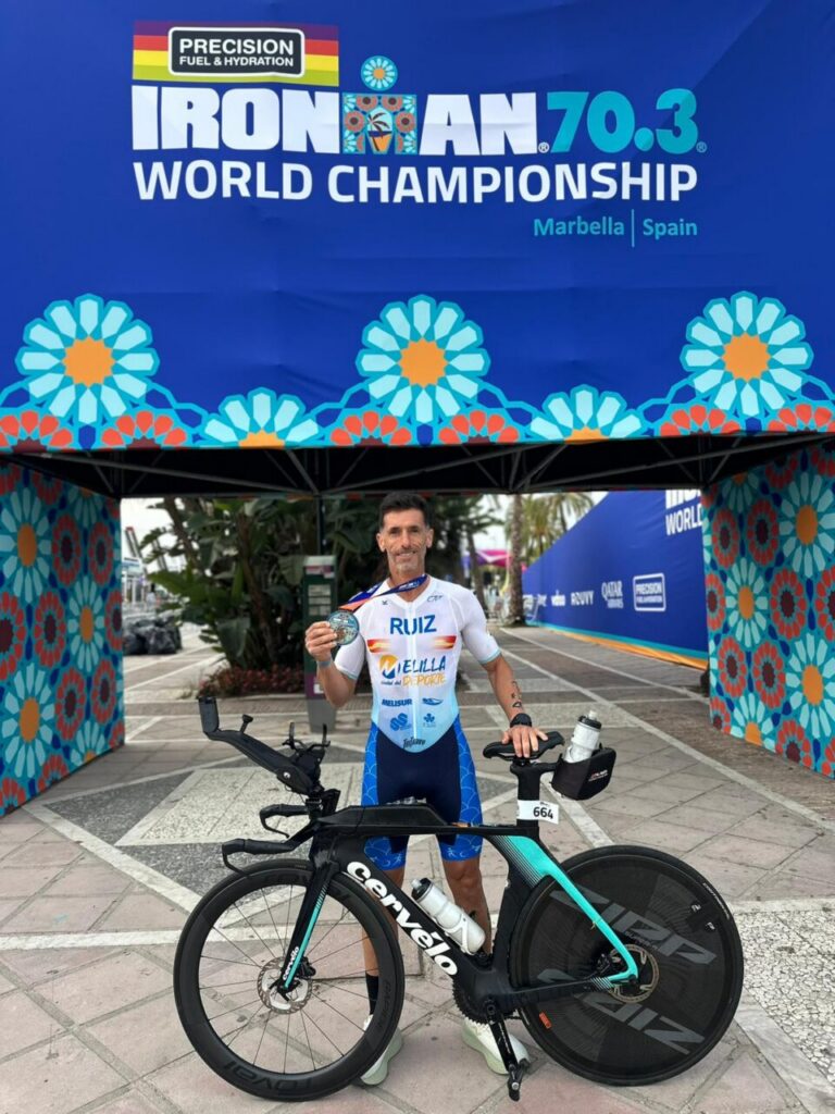 Luismi Ruiz sosteniendo una medalla en el Mundial de IRONMAN 70.3 en Marbella.
