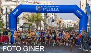 Corredores iniciando la XIII Media Maratón en Melilla bajo un arco de meta.