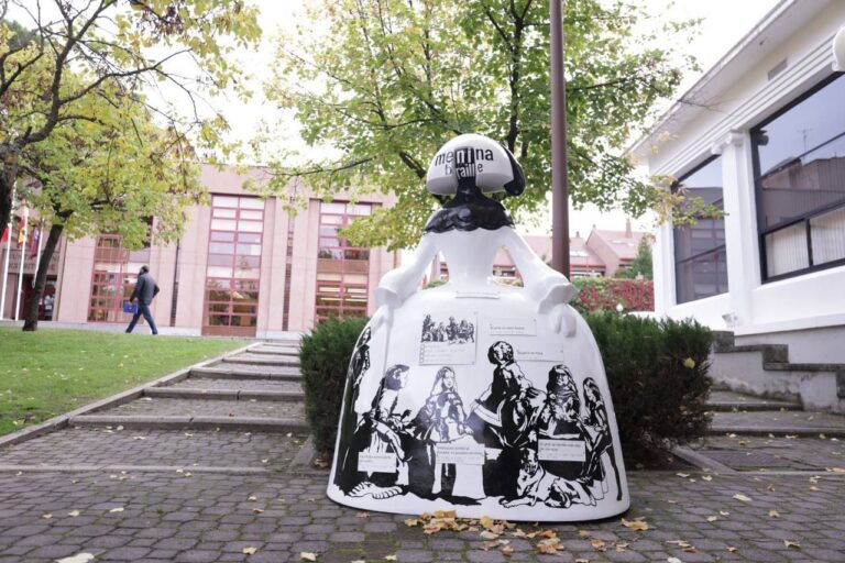 Escultura de Menina en braille en Madrid con fondo de árboles.