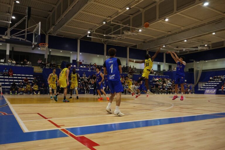 Jugadores de baloncesto en acción durante un partido en el Pabellón Guillermo García Pezzi.