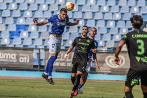 Jugador de fútbol saltando para cabecear el balón en un partido