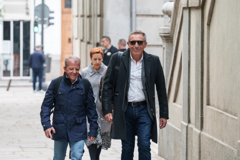 Tres personas caminando por una calle, una de ellas sonríe.