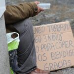 Persona en situación de vulnerabilidad con cartel pidiendo ayuda en Melilla